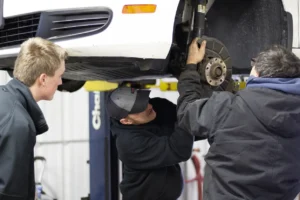 3 young men working on a car